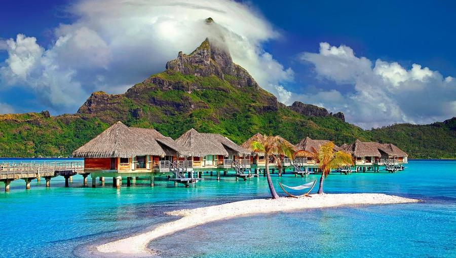 A landscape shot of Bora Bora's overwater bungalows and mountain.